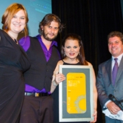 2 women and 2 men smile at the camera with an award