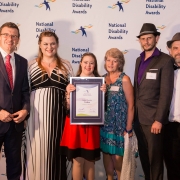 a group of people smile at the camera with an award