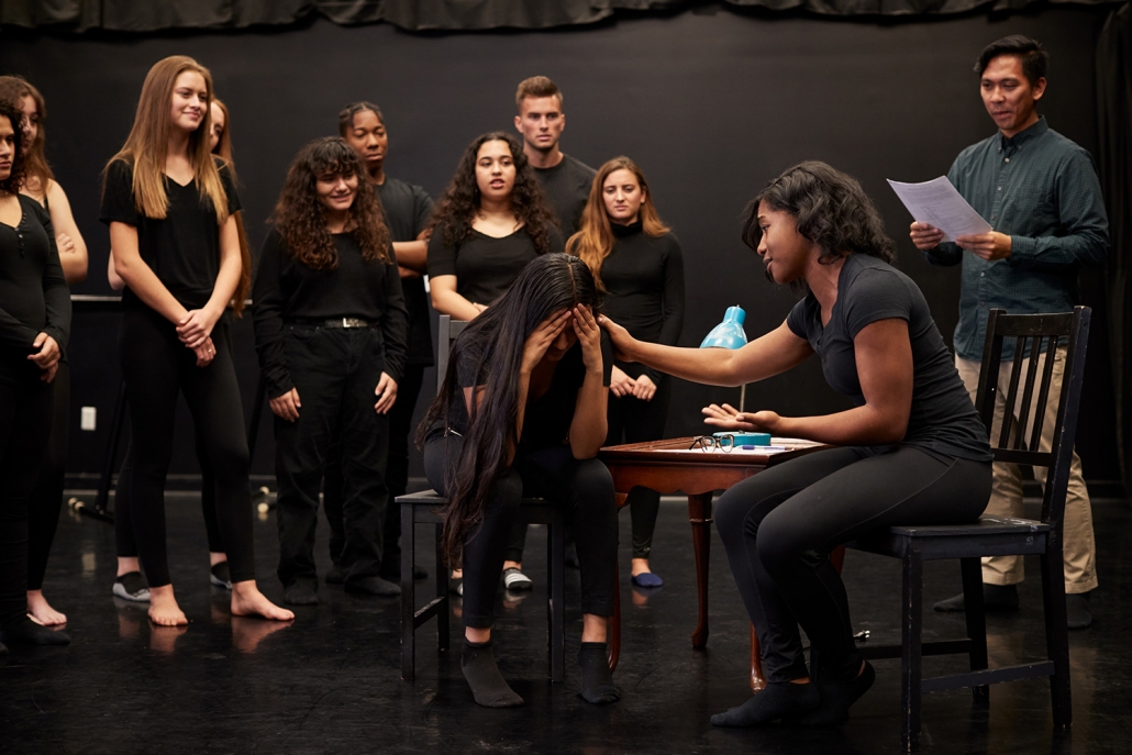 A multicultural group of actors acting on stage