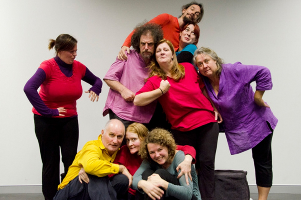 A group of actors pose in various positions