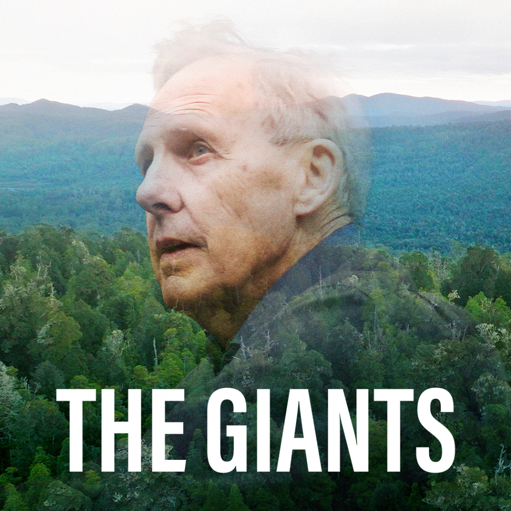 A landscape of forests into the horizon with an image of a man with great thinning hair looking off to the left thoughtfully. The text' The Giants' written in large white font