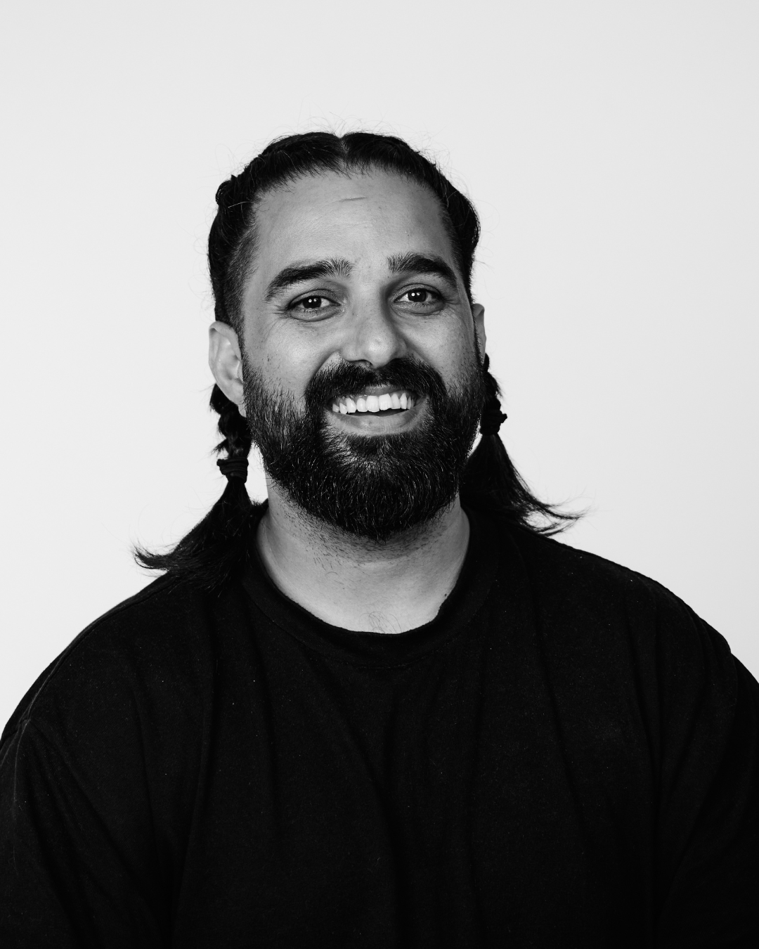 A man in a black shirt smiling at the camera