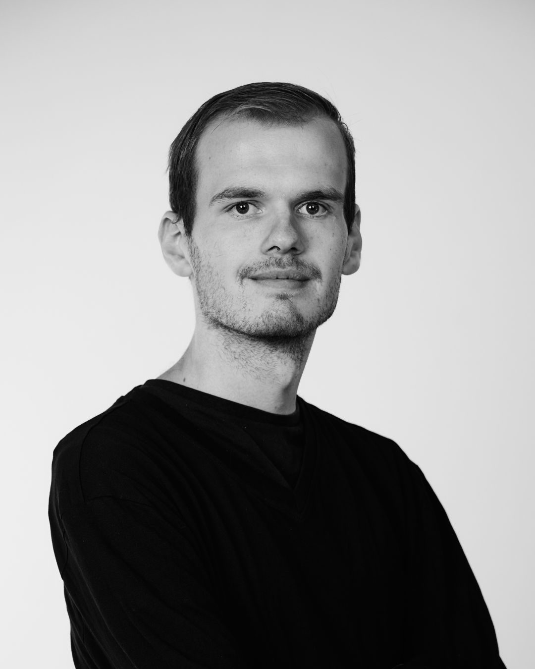 A man in a black shirt smiling at the camera