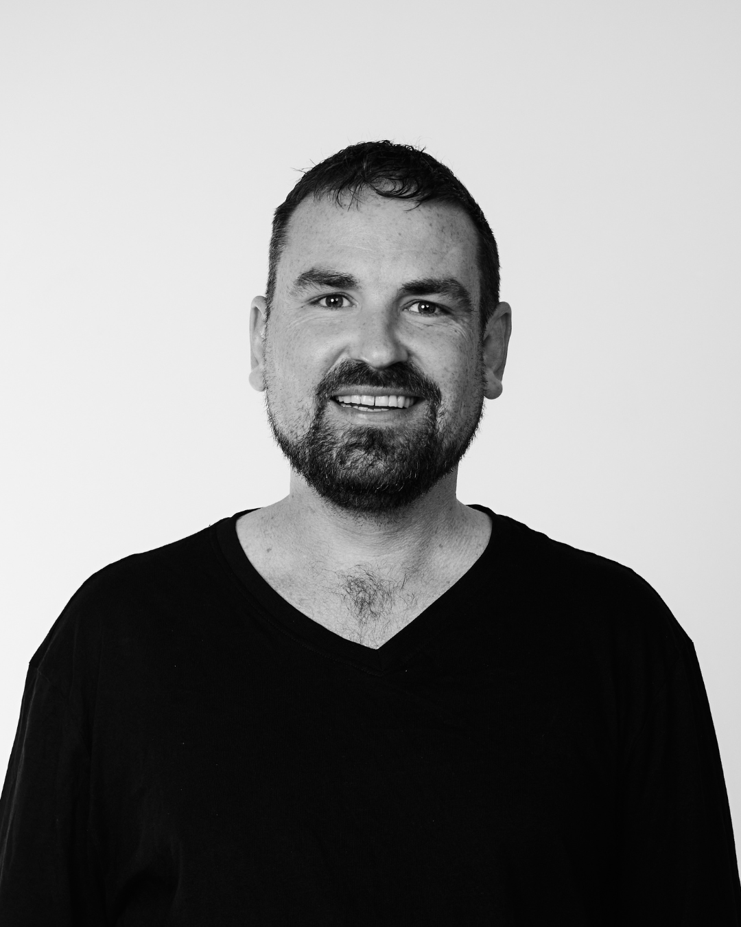 A man in a black shirt smiling at the camera