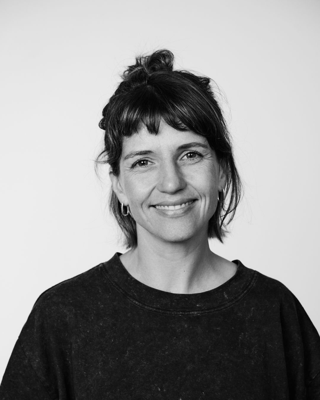 A woman in a black shirt smiling at the camera