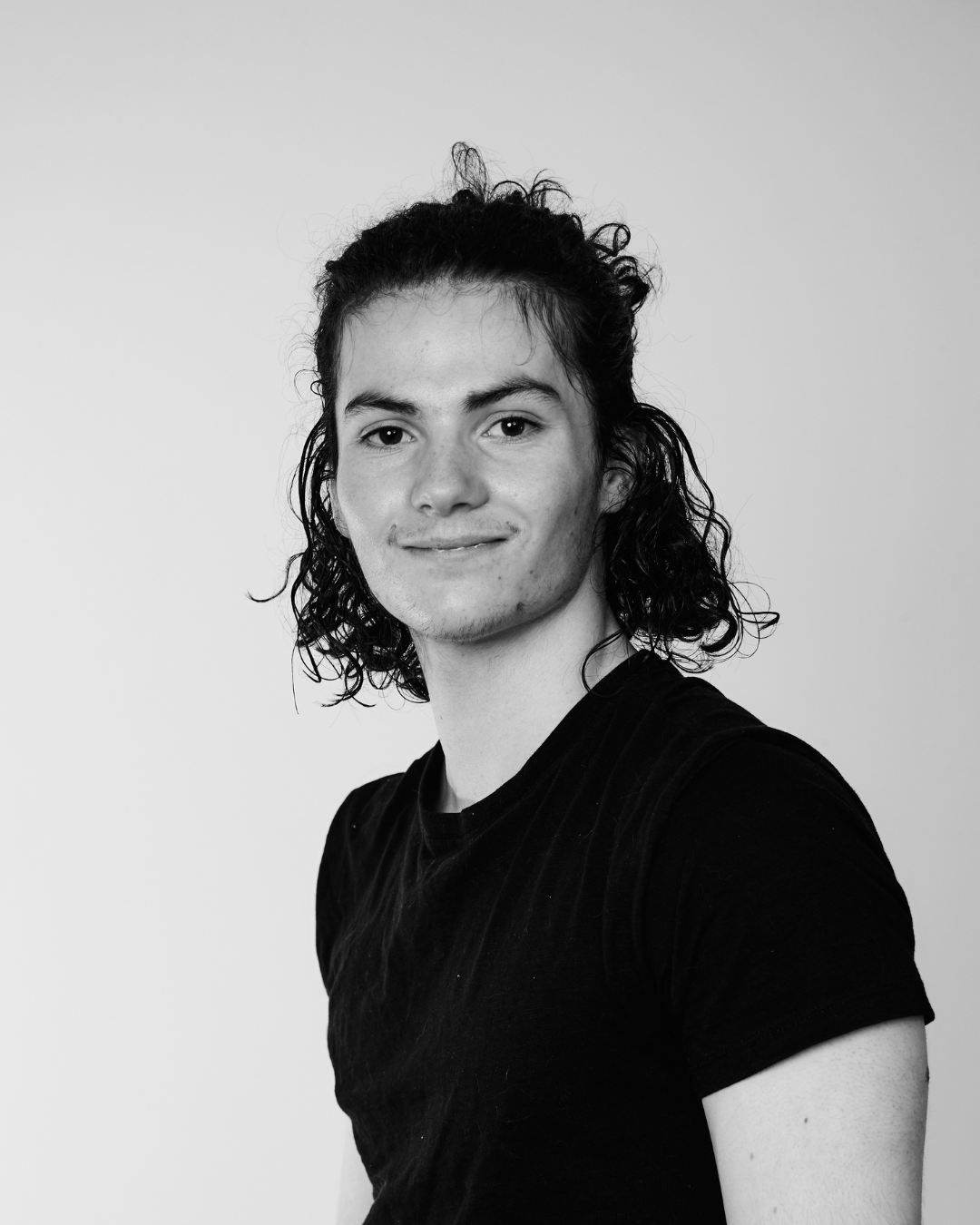 A man in a black shirt smiling at the camera