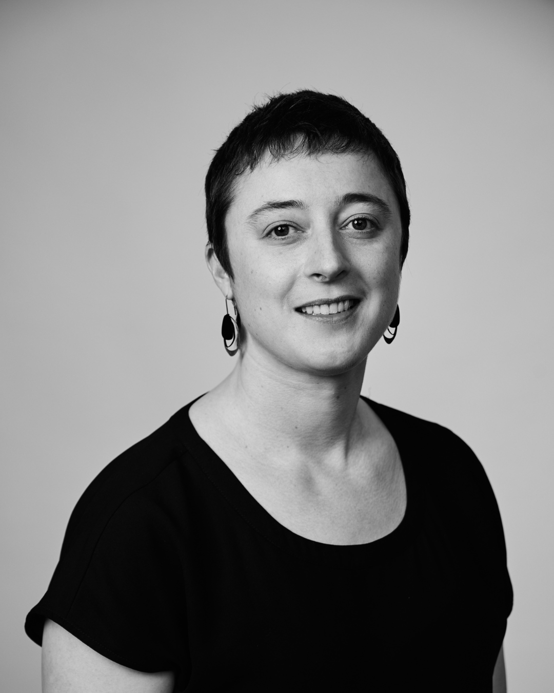 A woman in a black shirt smiling at the camera