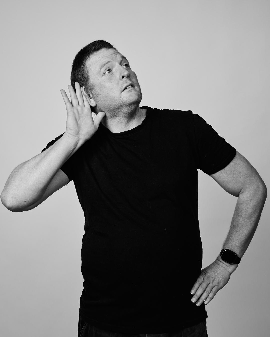 A man in a black shirt smiling at the camera